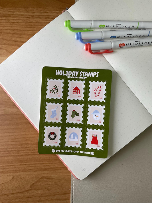 Holiday stamps sticker sheet featuring 9 cute stamps that include illustrations of mistletoe, stocking, candy cane, snow globe, and other holiday decorations.
