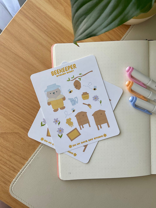 This stationery sticker sheet features a bee theme and has 15 colorful illustrations. These adorable illustrations includes a bear beekeeper, honey hives, bees, flowers and flowers. These glossy stickers are perfect for planners and bullet journals.