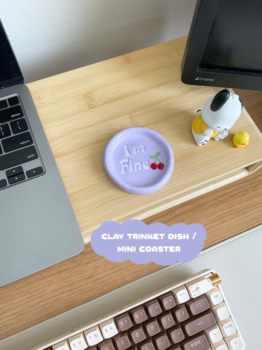 This cute tray dish has so many fun purposes. You can use this to hold your jewelry, simply use as a decor piece in your room or on your desk, or even as a mini coaster for a small can. This design is a light purple base, features the verbiage "I'm Fine" and has cherries painted on.
