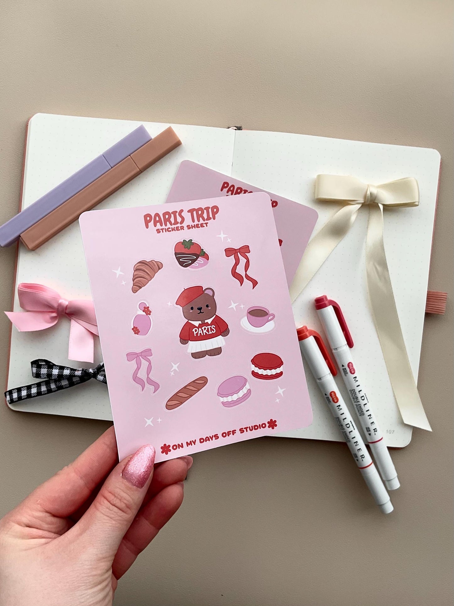 This stationery sticker sheet features a Paris Trip theme and has 10 colorful illustrations. This includes a bear in a Paris sweater, bows, chocolate dipped strawberries, croissant, perfume, macaroons and a french baguette. These glossy stickers are perfect for planners and bullet journals.&nbsp;