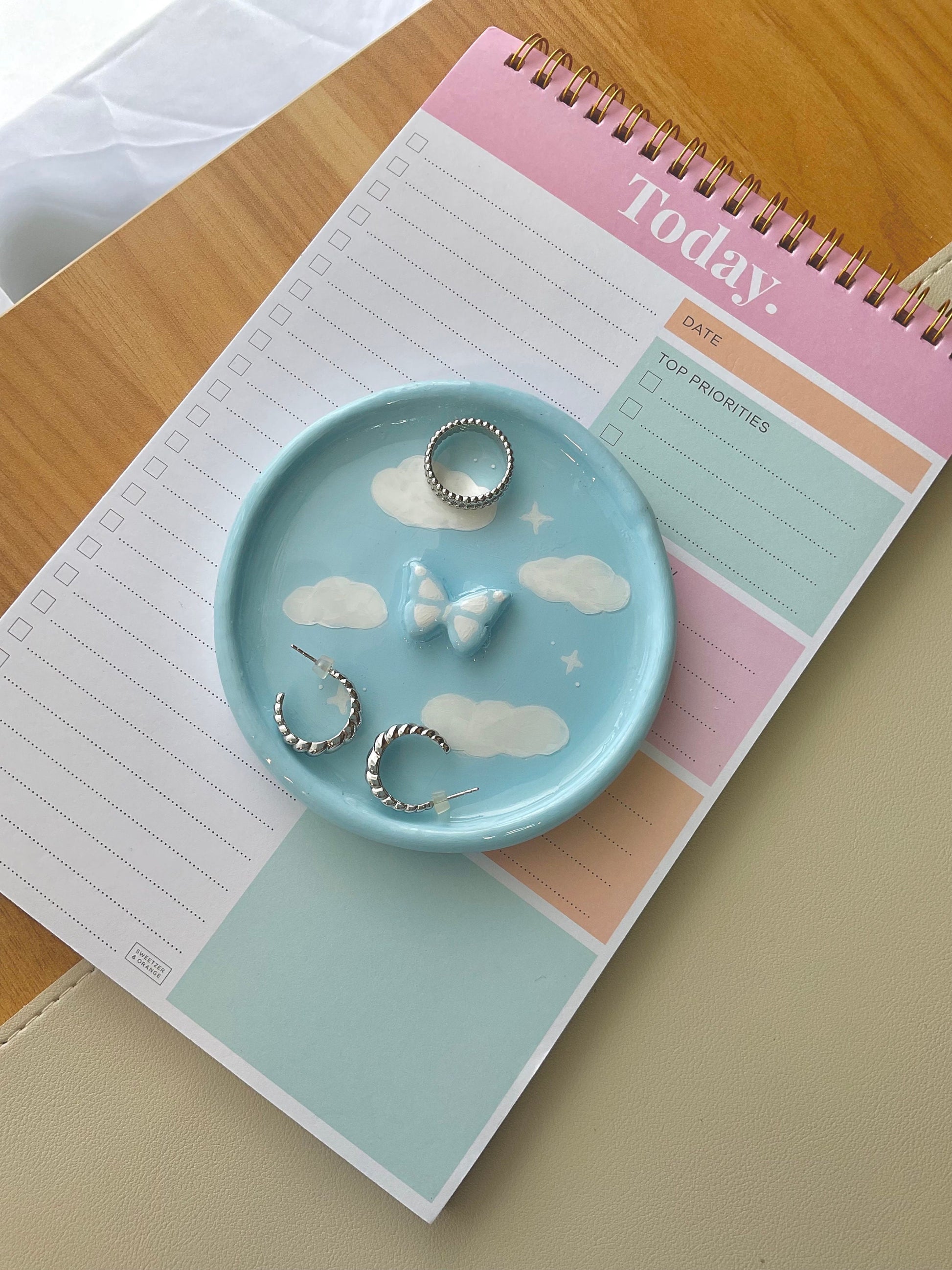 Dreamy handmade clay jewelry dish with clouds painted on and a 3D butterfly in the center. 